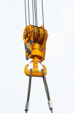 the pulley and hook of a tower cranes  against a blue sky