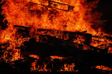 A large fire burning wood in a summer night close up