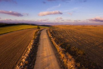 Fototapeta na wymiar Aerial view of rural road in beautiful countryside landscape at sunset .
