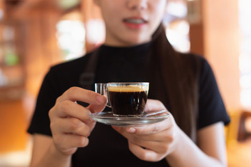 Hot espresso coffee in the woman's hand or the office staff during the morning and lunch break.