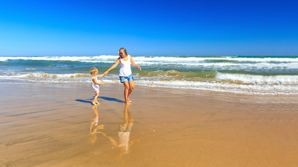Fototapeta premium Happy mother and daughter spend their holidays on the seashore.
