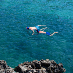 Two men in snorkeling equipment at sea. Active holidays.