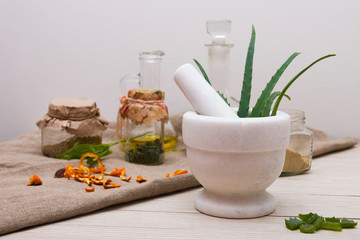 white stone cup with aloe leaves, natural medicine, natural ingredients and medicines for the prevention and treatment of seasonal colds, light background, copy space, hot sales