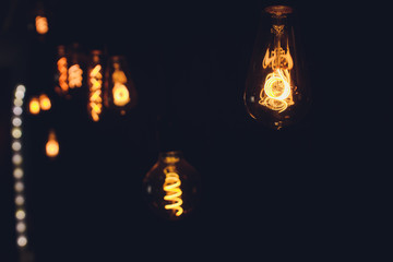 light bulb Edison filament retro vintage decor on brick wall background. Lighting decoration.