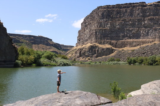 Beautiful lake landscape in Idaho with boy pointing to something in distance
