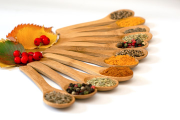 Fragrant dry spices in wooden spoons on white background. Pattern.