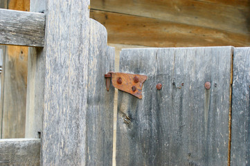 antique metal door hinge.  wooden window with old forged door hinge