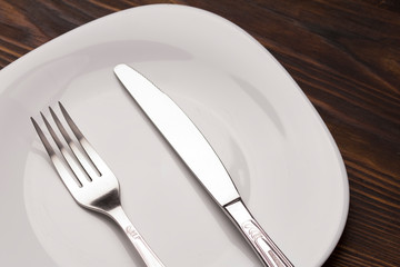 Fork And Knife on Plate. dark wood table 