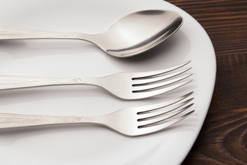 Fork And spoon on Plate On wood table . Dishes and cutlery. 