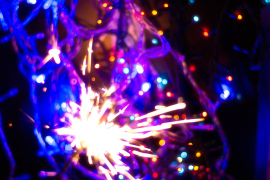 New year holiday Sparkler on the background of bright colorful bokeh. Blur.