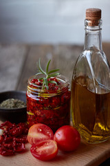 Sun-dried tomatoes with Provencal herbs, garlic and olive oil on a rustic wooden surface, selective focus