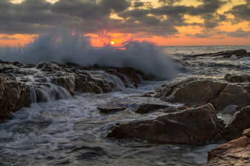 Beutiful sunrise seascape with rocky beach and crashing waves on cape Akin near Chernomorets, Bulgaria.