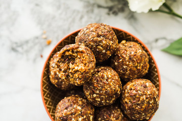 Energy protein balls with healthy ingredients on marble table. Home made with dates, peanut butter,...