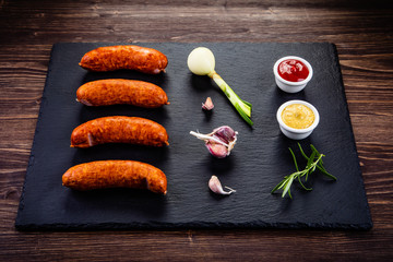 Raw sausages and ingredients on cutting board