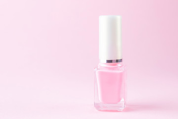 Pink nail polish on a pastel pink background. The concept of beauty, manicure, for women. Minimalism, place for text.