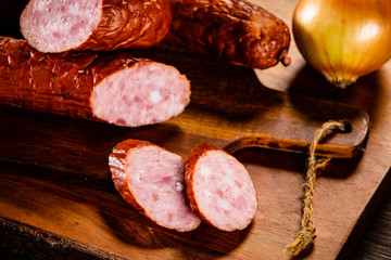 Raw sausages and vegetables on cutting board