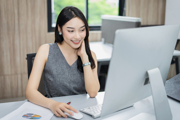 Portrait of beautiful happy smiling young businesswoman working on her computer in the office.,sitting on workplace.,Happy working.