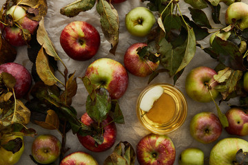 top view of glass with cider near scattered apples