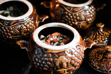 String beans with meat, potatoes, tomatoes, mushrooms, cheese and herbs in mayonnaise sauce, cooked in brown pots
