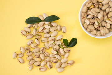 Nuts, pistachios from above on yellow background