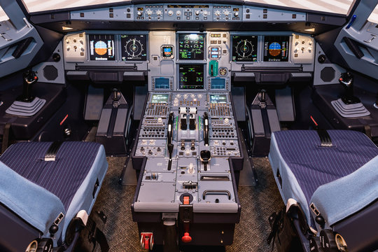 Cockpit of airliner simulator. Switches and dials visible in the background.