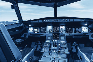 Cockpit of airliner simulator. Switches and dials visible in the background. - obrazy, fototapety, plakaty