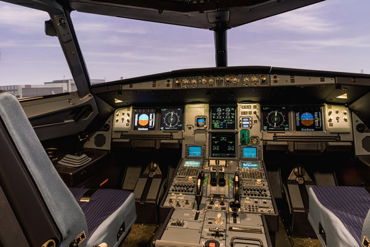 Cockpit of airliner simulator. Switches and dials visible in the background.