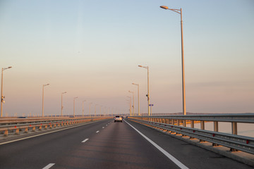 direct line of the road through the Kerch Strait with transport at dawn in summer