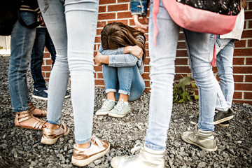 sad intimidation moment. girl sit on the ground Bullying in Schoolyard