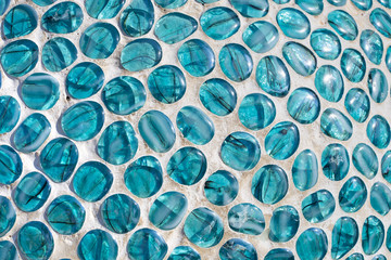 background of glass stones of blue color in the form of drops of water laid out by mosaic