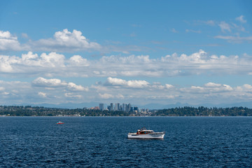 Leisure boat cruising on lake with the Bellevue skyline in the distance