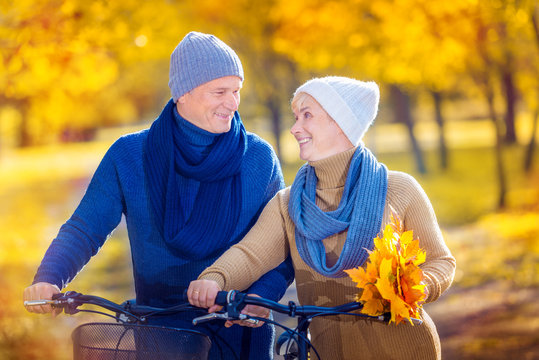a senior couple relaxing outdoors in autumn park