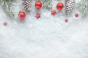 Weihnachtlicher Hintergrund mit Schnee Christbaumkugeln und Tannenzapfen, Ansicht von oben