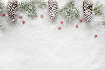 Weihnachtlicher Hintergrund mit Schnee und Tannenzapfen