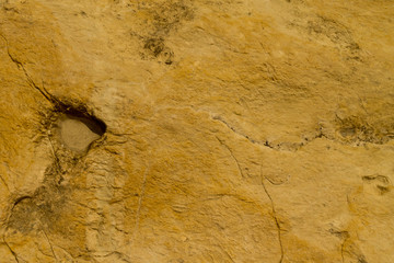 Rugged yellow rock texture with a hole