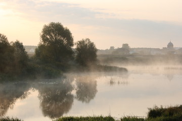 Fototapeta premium Morning fog on the river overlooking the village