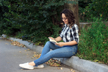 Fototapeta na wymiar girl in the park reads a book 