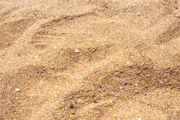 background of structural yellow coarse sea sand illuminated by the summer sun