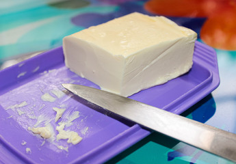 A piece of butter in an oil can trimmed with a knife.