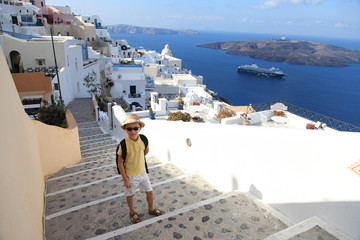 Obraz premium Portrait of young boy in hat on the streets of Fira, Santorini, Greece