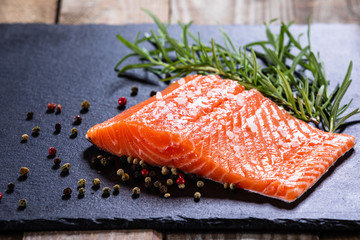 Fresh raw salmon fish served on black stone