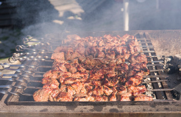 Delicious bbq grilling meat on open grill, outdoor kitchen. Food festival in city. tasty food roasting on skewers, food-court. Summer picnic.
