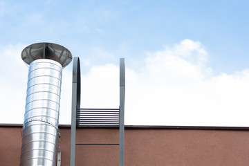 Tin pipe on the building wall and stairs to roof