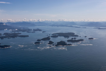 Aerial Landscape View of Beautiful Pacific Ocean Coast with Coastal Mountains at the background during a summer morning. Taken near Tofino and Ucluelet, Vancouver Island, British Columbia, Canada.