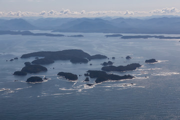 Naklejka na ściany i meble Aerial Landscape View of Beautiful Pacific Ocean Coast with Coastal Mountains at the background during a summer morning. Taken near Tofino and Ucluelet, Vancouver Island, British Columbia, Canada.