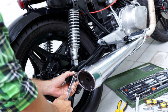 Mechaniker repariert ein Motorrad / Cafe Racer