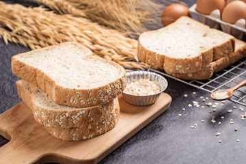 Sliced bread with sunflower seeds oat and sesame on a wooden plate.