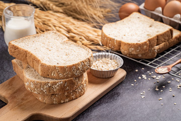 Sliced bread with sunflower seeds oat and sesame on a wooden plate.