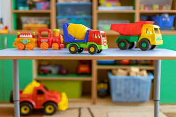 toy cars on the table.Children's playroom with plastic colorful educational blocks toys. Games floor for preschoolers kindergarten. interior children's room. Free space. 