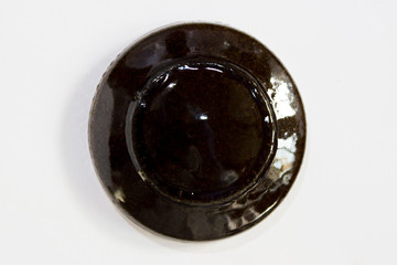 round clay probe with brown glossy glaze.